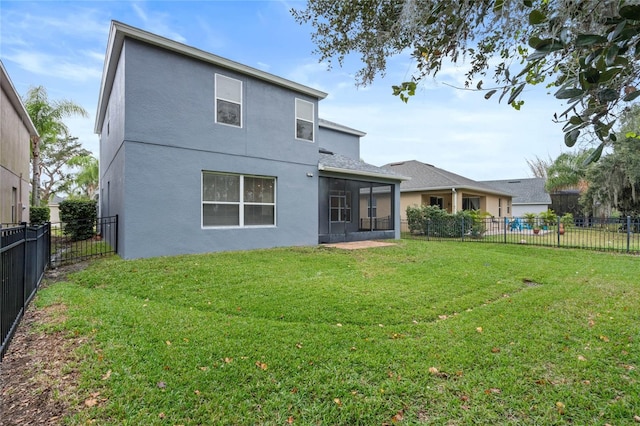 rear view of property featuring a sunroom and a yard