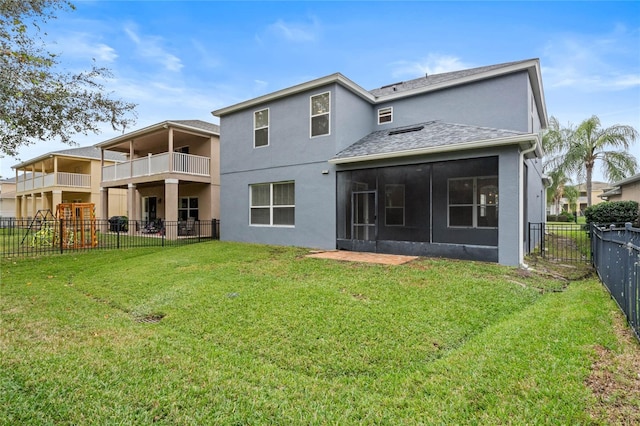 back of property with a sunroom and a yard