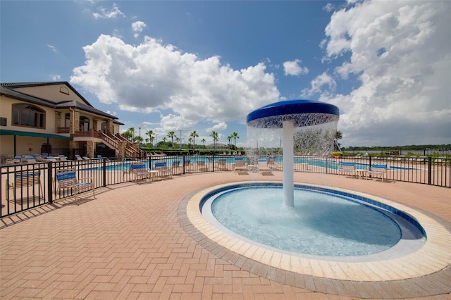 view of swimming pool featuring pool water feature and a patio