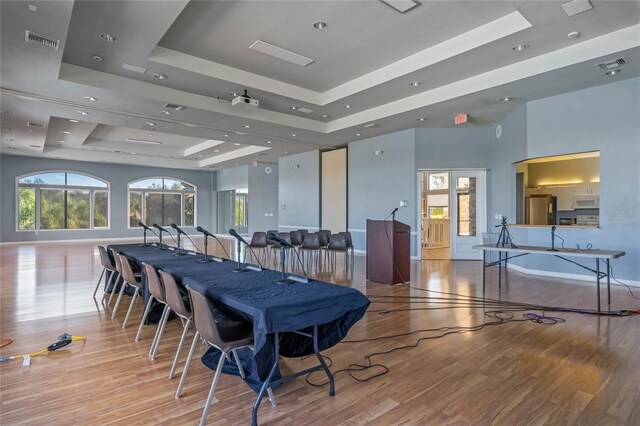 dining space featuring a raised ceiling and light hardwood / wood-style flooring