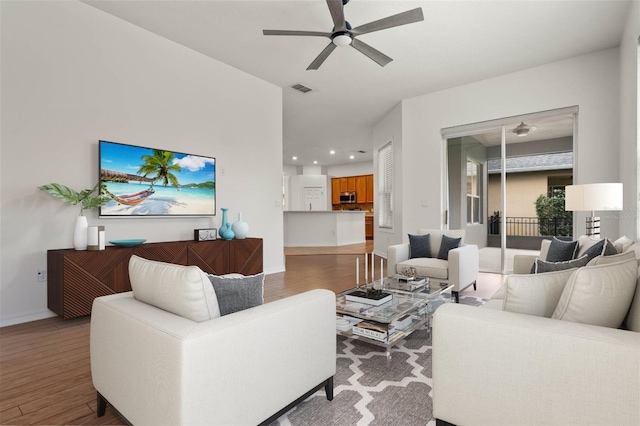 living room featuring hardwood / wood-style floors and ceiling fan