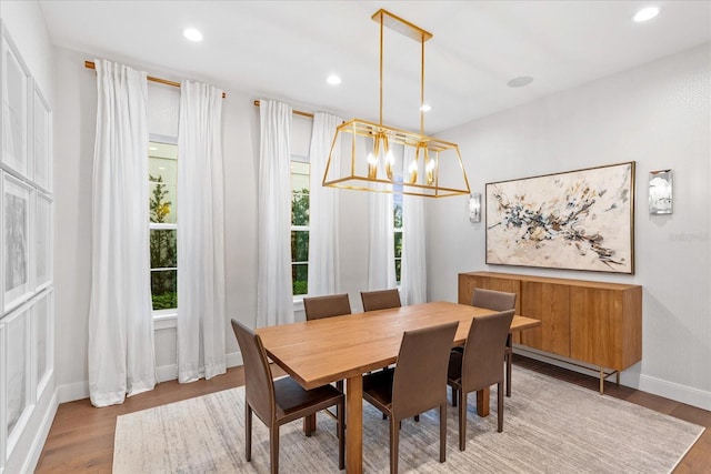 dining area featuring wood-type flooring and a notable chandelier