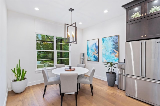 dining room with light hardwood / wood-style flooring and a notable chandelier