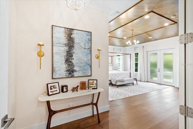 bedroom featuring access to exterior, french doors, a chandelier, wood ceiling, and hardwood / wood-style flooring