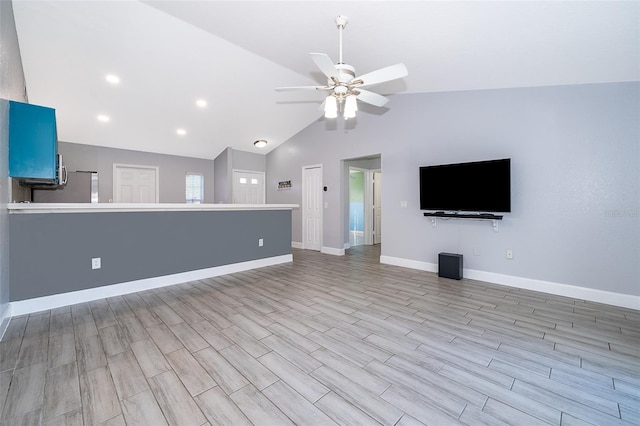 unfurnished living room with ceiling fan, lofted ceiling, and light wood-type flooring