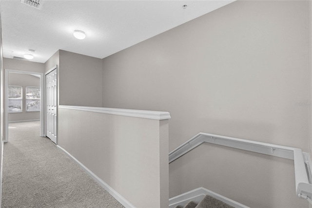 hallway featuring light colored carpet