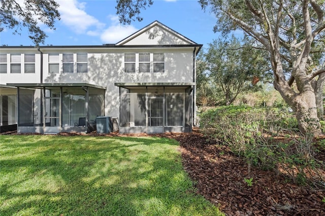 rear view of house featuring a lawn, a sunroom, and central AC unit