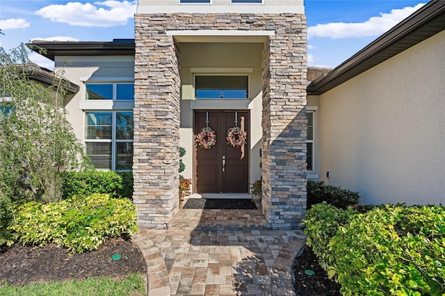 property entrance featuring stone siding and stucco siding