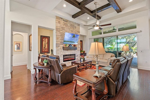 living room with baseboards, coffered ceiling, dark wood finished floors, a stone fireplace, and beam ceiling