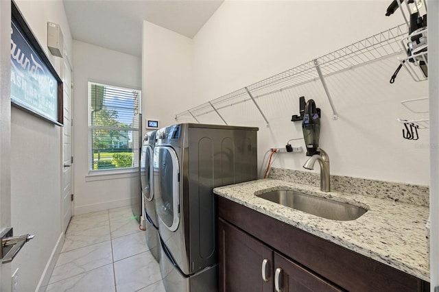 clothes washing area with a sink, baseboards, marble finish floor, cabinet space, and washing machine and clothes dryer