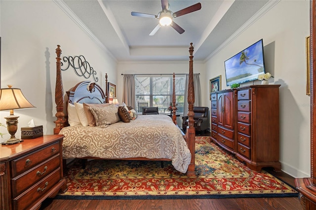 bedroom with dark wood-style floors, baseboards, a raised ceiling, and crown molding