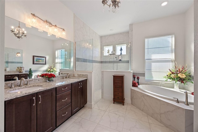 bathroom featuring a garden tub, a sink, marble finish floor, walk in shower, and an inviting chandelier