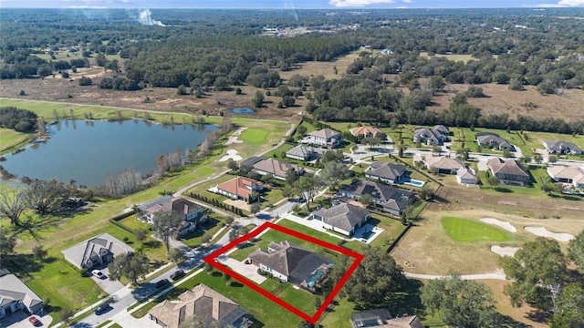 birds eye view of property featuring a residential view, a water view, and a wooded view