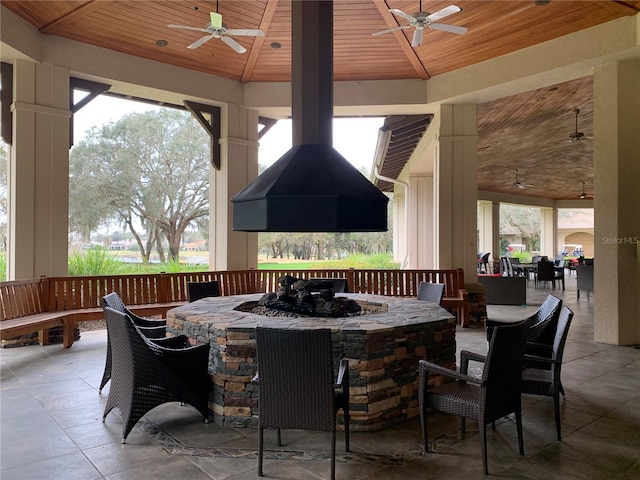 view of patio / terrace featuring a fire pit, a gazebo, outdoor dining area, and ceiling fan