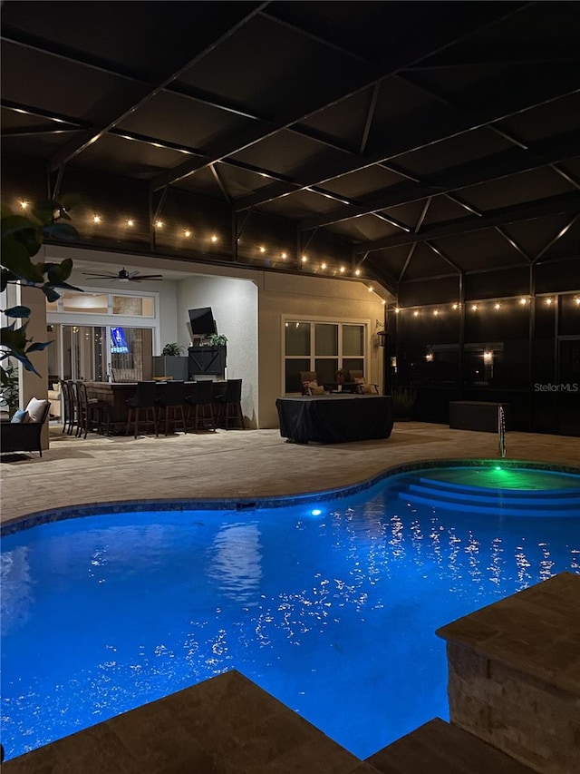 outdoor pool with glass enclosure and a patio