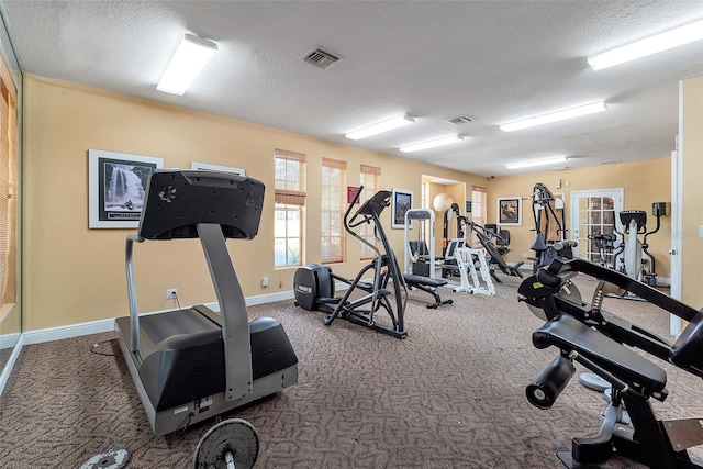 gym with dark carpet and a textured ceiling