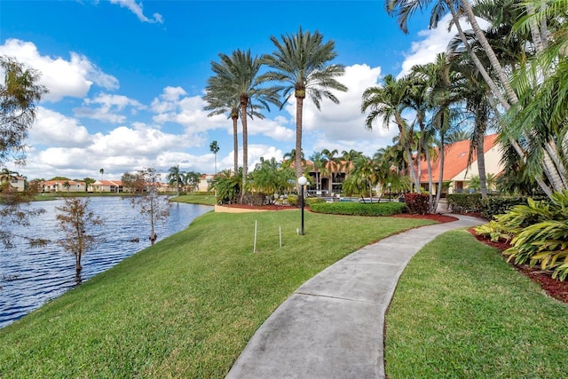 view of property's community featuring a lawn and a water view