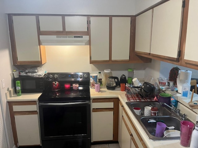 kitchen with sink, electric range oven, and light tile patterned floors