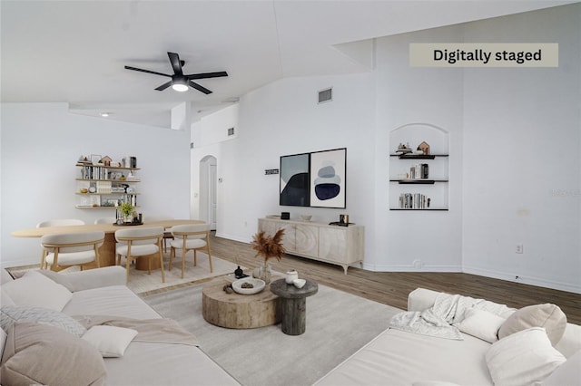 living room with wood-type flooring, high vaulted ceiling, and ceiling fan