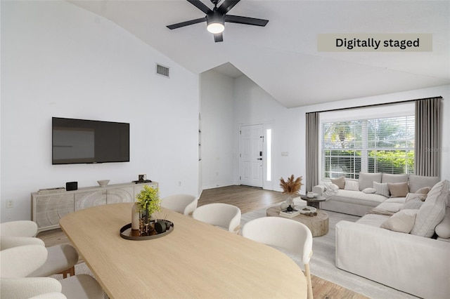 living room with ceiling fan, high vaulted ceiling, and light hardwood / wood-style floors