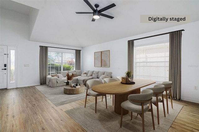 dining area featuring ceiling fan, high vaulted ceiling, and light hardwood / wood-style floors