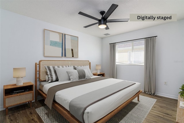 bedroom featuring ceiling fan, dark hardwood / wood-style flooring, and a textured ceiling