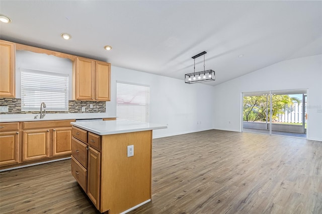 kitchen with plenty of natural light, dark hardwood / wood-style flooring, a kitchen island, pendant lighting, and backsplash