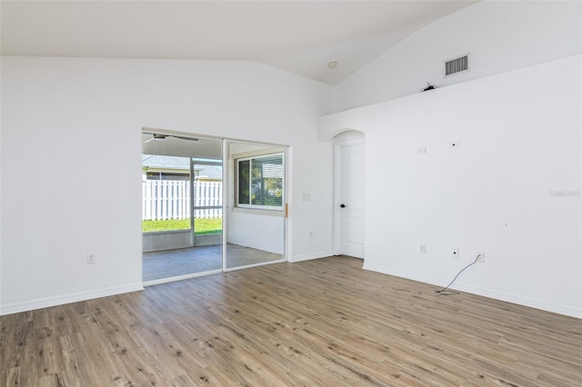 empty room with lofted ceiling and light wood-type flooring