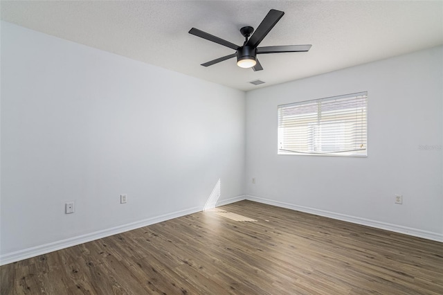 empty room featuring dark hardwood / wood-style floors, a textured ceiling, and ceiling fan