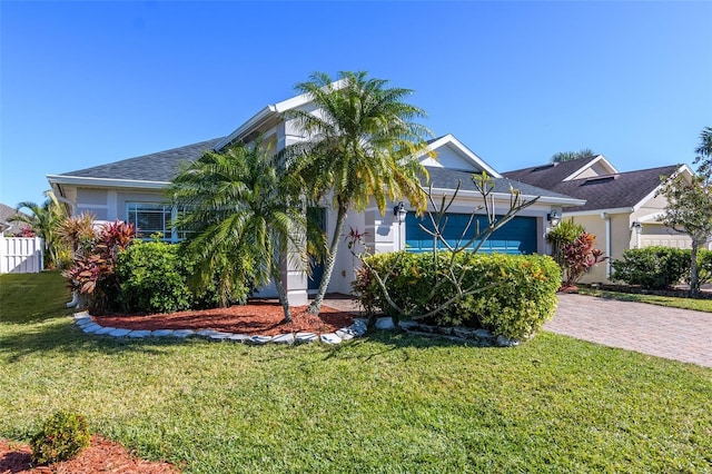 view of property hidden behind natural elements with a garage and a front yard