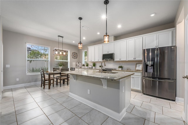 kitchen featuring pendant lighting, sink, an island with sink, appliances with stainless steel finishes, and white cabinetry