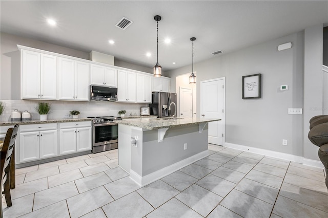 kitchen with white cabinetry, a center island with sink, and stainless steel appliances