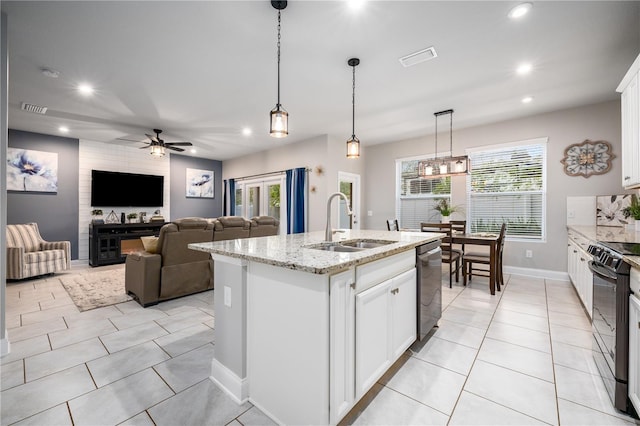 kitchen featuring white cabinets, black range with electric stovetop, sink, an island with sink, and decorative light fixtures