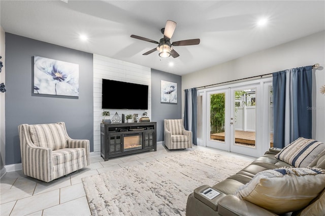 tiled living room featuring ceiling fan, a fireplace, and french doors