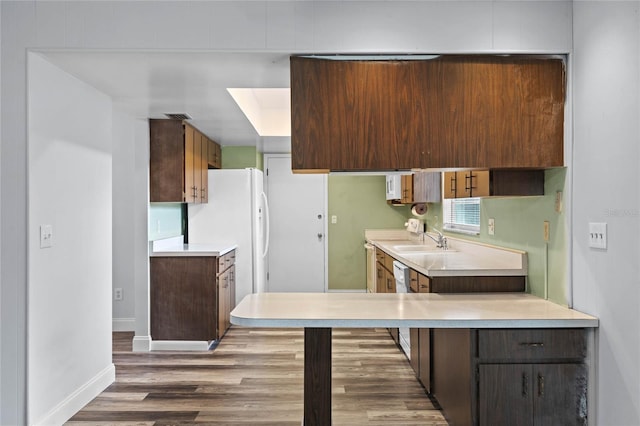 kitchen with dark brown cabinetry, dark hardwood / wood-style floors, white refrigerator, and sink