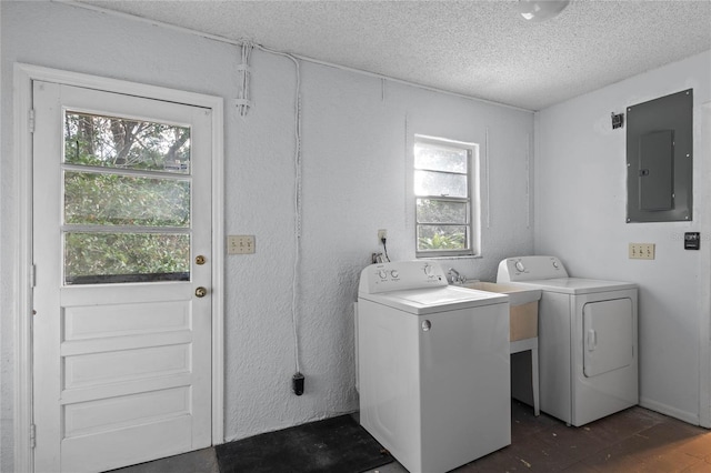 laundry room with washing machine and clothes dryer, electric panel, a healthy amount of sunlight, and a textured ceiling