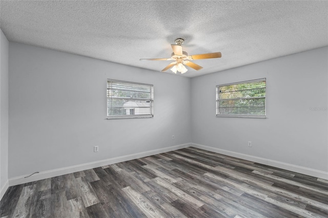 unfurnished room with dark hardwood / wood-style flooring, a textured ceiling, and a wealth of natural light