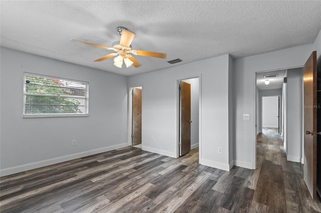 unfurnished bedroom with a textured ceiling, ceiling fan, and dark wood-type flooring