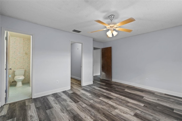 unfurnished bedroom with ensuite bathroom, a textured ceiling, ceiling fan, dark hardwood / wood-style floors, and a closet