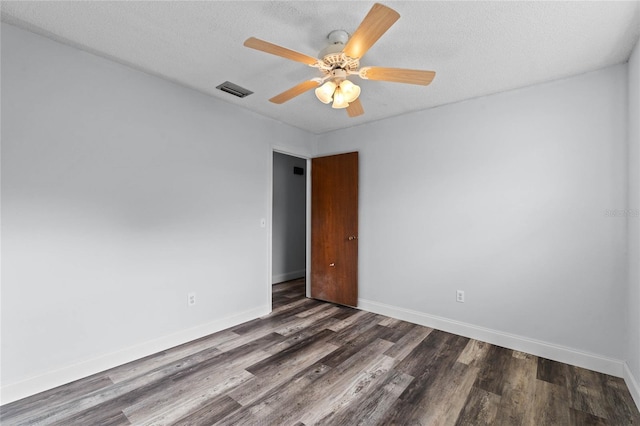 empty room featuring a textured ceiling, dark hardwood / wood-style flooring, and ceiling fan