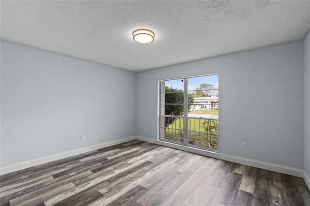 spare room featuring wood-type flooring and a textured ceiling