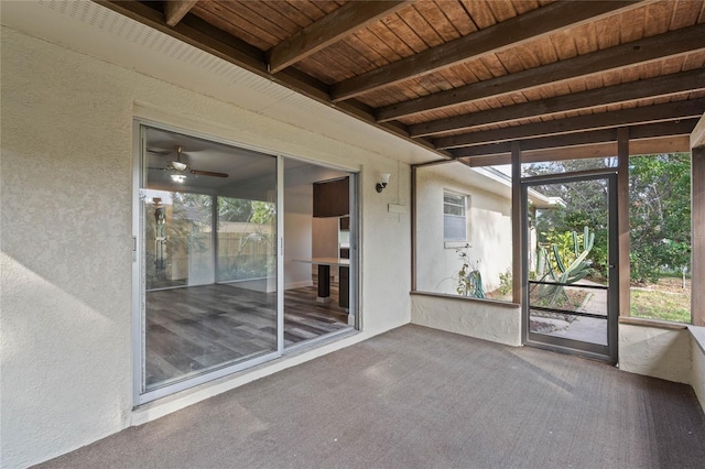 unfurnished sunroom with ceiling fan, beam ceiling, and wood ceiling