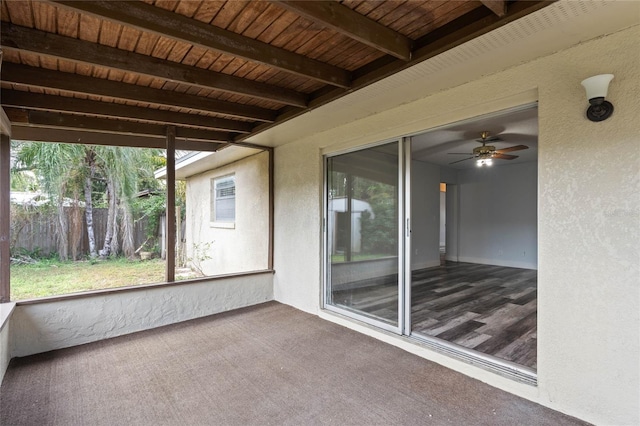 unfurnished sunroom with beamed ceiling, ceiling fan, and wood ceiling