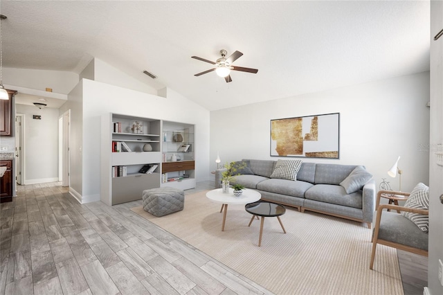 living room with ceiling fan, light hardwood / wood-style flooring, and lofted ceiling