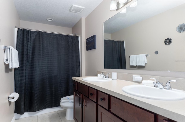 bathroom featuring vanity, a textured ceiling, tile patterned floors, and toilet