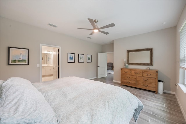 bedroom featuring hardwood / wood-style floors, ensuite bathroom, and ceiling fan