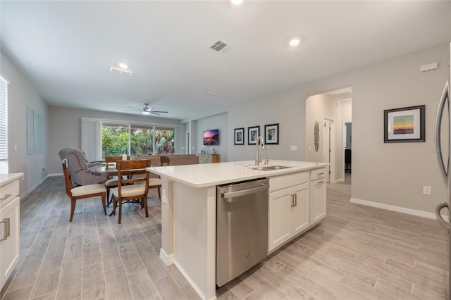 kitchen with dishwasher, a kitchen island with sink, white cabinets, sink, and ceiling fan