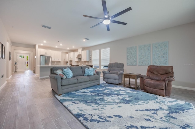 living room featuring ceiling fan and light wood-type flooring