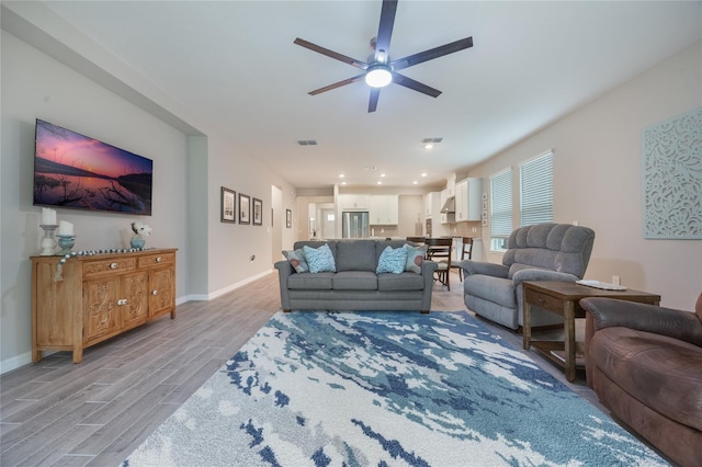 living room featuring light wood-type flooring and ceiling fan