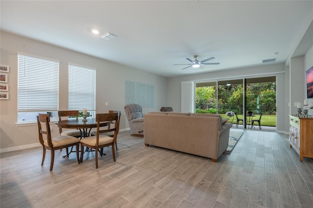 living room with ceiling fan, plenty of natural light, and light hardwood / wood-style flooring